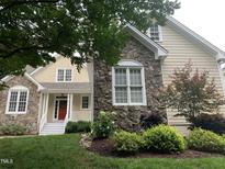 Charming two-story home with stone and vinyl siding and a well-manicured lawn at 1012 Coram Fields Rd, Wake Forest, NC 27587