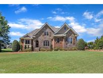 Beautiful two-story stone and brick home with mature landscaping and a manicured lawn at 105 Somerley Dr, Garner, NC 27529