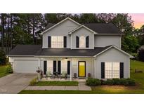 Charming two-story home with light siding, black shutters and a bright yellow front door at 11233 Jeffreys Ln, Wake Forest, NC 27587