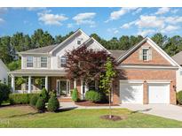 Charming two-story home featuring a brick and siding exterior, a two-car garage, and a beautifully landscaped front yard at 1603 Timber Wolf Dr, Durham, NC 27713