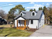 Charming two-story home with white siding, black trim, dormers, and a cozy front porch at 18 W Academy St, Wendell, NC 27591
