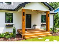Charming front porch featuring wooden columns, window boxes and black front door at 18 W Academy St, Wendell, NC 27591