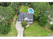 Aerial view of home with in-ground pool, mature trees, and long driveway at 1817 Foxbrook Dr, Raleigh, NC 27603