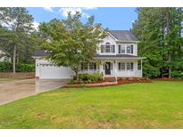 Traditional two-story home with a well-manicured lawn and beautiful landscaping at 1817 Foxbrook Dr, Raleigh, NC 27603