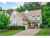 Charming two-story home with a manicured lawn, inviting porch, and attached garage at 1939 Mostyn Ln, Apex, NC 27502