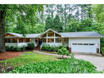 Charming single-story home featuring a well-maintained lawn, mature trees, and a two-car garage at 2004 Flagstone Pl, Raleigh, NC 27612