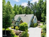 Charming home featuring lush landscaping, a spacious driveway, and a well-maintained yard at 201 Margaret Mann Way, Pittsboro, NC 27312
