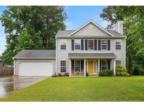 Charming two-story home with a well-manicured lawn, attached garage, and inviting yellow front door at 202 Stonecreek Dr, Apex, NC 27539