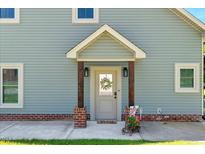Inviting home entrance featuring a charming front door with a wreath and a decorative garden cart at 2258 Sanders Rd, Stem, NC 27581