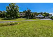 Expansive front yard with a charming brick home and detached garage under a clear blue sky at 2371 Nc 210, Smithfield, NC 27577