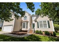 Charming two-story home with cream siding, manicured lawn, and inviting green front door at 2412 Colony Woods Dr, Apex, NC 27523