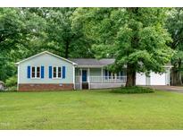 Charming single-story home with light green siding, blue shutters, and a well-manicured lawn at 2532 Rolling Meadows Dr, Raleigh, NC 27603
