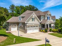 Beautiful home with a three-car garage, a basketball hoop, well-manicured lawn, and attractive landscaping at 2538 Tuffeto, Apex, NC 27502