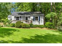 Charming single-story home features a welcoming front porch, tidy landscaping, and beautiful lawn at 26 Rogerson Dr, Chapel Hill, NC 27517