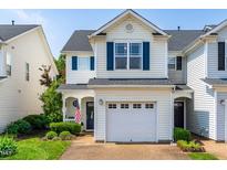 Charming townhouse with blue shutters, a white garage door, and a beautifully landscaped front yard at 2635 Asher View Ct, Raleigh, NC 27606