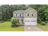 Charming two-story home with a two-car garage and beautifully landscaped front yard at 2709 Banks Lake Ct, Fuquay Varina, NC 27526