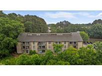 Stunning aerial view of a large, multi-story condo building featuring multiple balconies and nestled amongst lush greenery at 3077 Huntleigh Dr, Raleigh, NC 27604