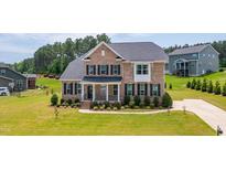 Charming two-story brick home featuring a well-manicured lawn and inviting front porch at 367 Tayside St, Clayton, NC 27520