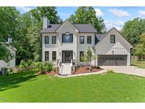 Inviting two-story home with a well-manicured lawn, painted brick and modern farmhouse accents at 4408 Queenstown Ct, Raleigh, NC 27612