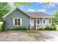 Charming single-story home featuring gray wood shingles, white trim, and a welcoming front porch with a small yard at 4575 Wendell Blvd, Wendell, NC 27591