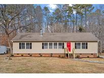 Charming single-story home with a bright red door and cozy front yard, perfect for curb appeal at 4720 Brigadoon Dr, Durham, NC 27705