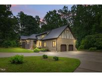 Inviting brick home featuring an attached two-car garage, manicured lawn, and a spacious circular driveway at 6617 Whitted Rd, Fuquay Varina, NC 27526