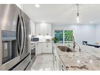 Bright kitchen featuring white cabinets, stainless steel appliances, and a large island with granite countertop at 6617 Whitted Rd, Fuquay Varina, NC 27526