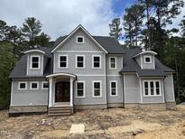 New two-story home with gray siding, black roof, and inviting covered front porch at 79 Oldham Estate Dr, Chapel Hill, NC 27517