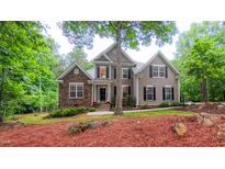 Charming two-story home featuring a stone facade and beautiful landscaping with mature trees at 99 Grassy Creek Way, Chapel Hill, NC 27517