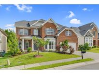 Beautiful two-story brick home with manicured lawn, gray shutters, and attached two car garage at 106 Elmsford St, Durham, NC 27703