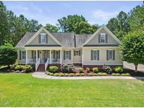 Charming home featuring a landscaped front yard, cozy porch, and neutral siding, exuding curb appeal at 113 Cedardale Ct, Clayton, NC 27520