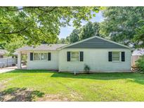 Charming single-story home featuring a classic white brick exterior and well-maintained lawn with mature trees at 118 Lynn Rd, Durham, NC 27703