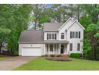 Charming two-story home with a manicured lawn, attached two-car garage, and inviting front porch at 1208 Mossy Glade Cir, Apex, NC 27502
