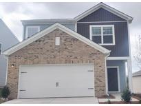 Charming two-story home with a brick facade and an attached two-car garage at 1208 Solace Way, Rolesville, NC 27571