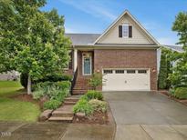 Charming brick home featuring manicured landscaping and an attached two-car garage at 136 Shadow Hawk Dr, Durham, NC 27713