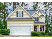 Charming home featuring a two-car garage, manicured lawn, and traditional architectural details at 1984 Sadler Ave, Creedmoor, NC 27522