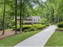 Traditional brick home featuring a lush, landscaped front yard and a long driveway at 2300 Valley Forge Dr, Raleigh, NC 27615