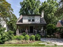 Charming two-story home with landscaped front yard and inviting covered porch with stone accents at 2303 Byrd St, Raleigh, NC 27608