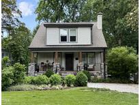 Charming two-story home featuring stone accents, a cozy front porch, and professionally landscaped front yard at 2303 Byrd St, Raleigh, NC 27608
