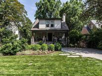 Charming two-story home featuring a landscaped yard with vibrant green grass and mature trees at 2303 Byrd St, Raleigh, NC 27608