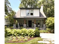 Charming home featuring a beautiful front yard with a stone porch, lush landscaping, and a cozy seating area at 2303 Byrd St, Raleigh, NC 27608