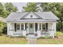 Charming exterior showcasing a well-maintained lawn, metal roof, and a welcoming front porch with gray trim at 2418 Highland Ave, Durham, NC 27704