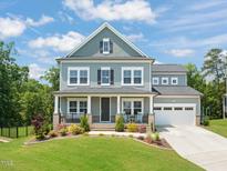Charming two-story home with a manicured lawn, lush landscaping, and inviting front porch at 2636 Nordmann Fir Rd, Raleigh, NC 27616