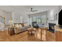 Bright living room features hardwood floors, fireplace, and multiple windows at 2744 Laurelcherry St, Raleigh, NC 27612