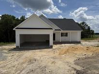 Newly constructed one-story home with a two-car garage and modern design against a partly cloudy sky at 2744 Rains Mill Rd, Princeton, NC 27569