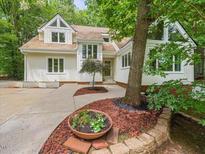 Charming home showcasing a landscaped front yard, tall trees, and bright exterior at 310 Heidinger Dr, Cary, NC 27511