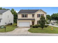 Charming two-story home with a well-maintained lawn and a two-car garage in a suburban neighborhood at 3705 Rivermist Dr, Raleigh, NC 27610