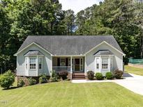 Charming single-story home featuring a manicured lawn, bay windows, and inviting front porch at 4132 Battle Field Dr, Garner, NC 27529