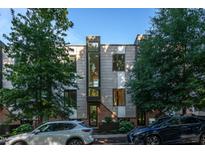 Modern townhome with gray siding, black framed windows, and brick accents, surrounded by lush trees at 414 Chavis Way, Raleigh, NC 27601