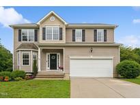 Charming two-story home featuring a manicured lawn, black shutters, and a two car garage at 50 Consella Way, Franklinton, NC 27525